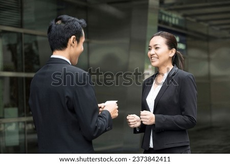 Asian Businessman presenting his business card to a businesswoman