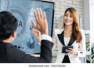 An Asian Businessman Is Presenting His Company Performance Report To His Boss Or Group Of Male And Female Colleagues With Confidence And Professionalism.