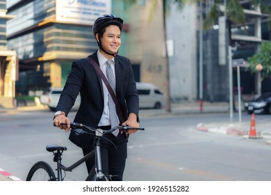 Asian businessman pushing his bicycle from home in the morning preparing to ride his bicycle to work. Eco tranportation.