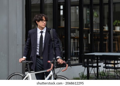 Asian businessman pushing his bicycle in the morning preparing to ride his bicycle to work. Eco tranportation
