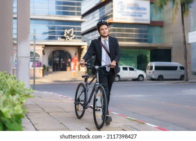 Asian businessman pushing his bicycle from home in the morning preparing to ride his bicycle to work. Eco tranportation.