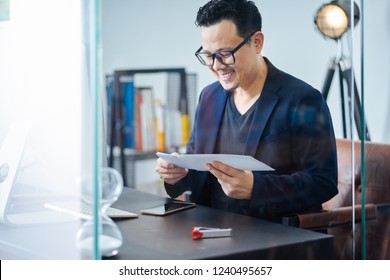 Asian businessman receive a letter with good news in a office .