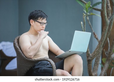 Asian Businessman Seat A Chair  Not Wear A Shirt Working With Laptop In Swimming Poolside. Work New Normal. Lifestyle Travel In Holiday Vacation. Relaxation Concept.