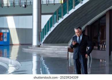 Asian Businessman senior manager working on smartphone remote working corporate business conference outside office. Business people using telecommunication technology working business and financial. - Powered by Shutterstock