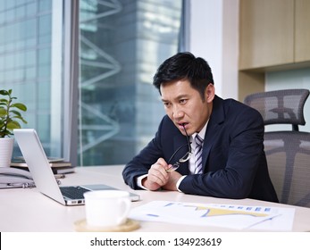 Asian Businessman Sitting And Thinking In Office.