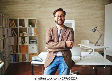Asian businessman standing by his desk in office
