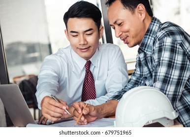 Asian businessman talking about detail plan building with engineer