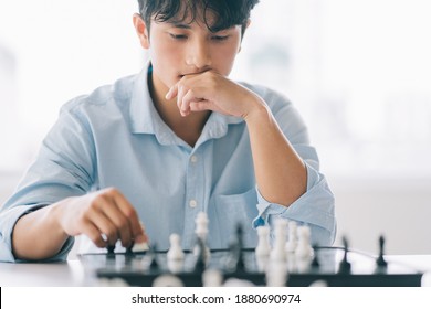 Asian Businessman Is Thinking About His Next Move On The Chess Board
