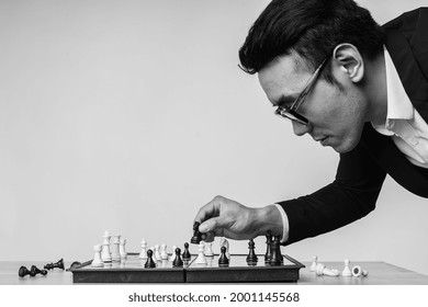 Asian Businessman Is Thinking About His Next Move On The Chess Board
