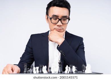 Asian Businessman Is Thinking About His Next Move On The Chess Board
