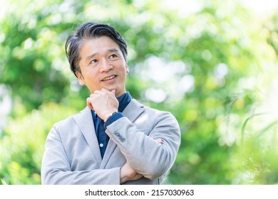 Asian Businessman Thinking In The Park