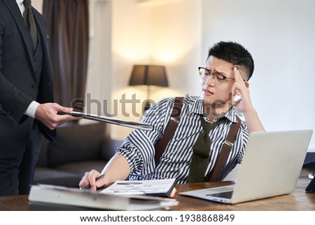 Asian businessman tired from adding work