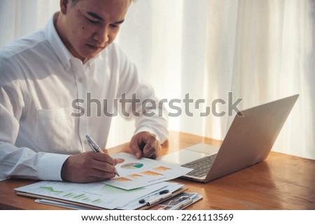 Asian Businessman type keyboard write financial graph chart Planning marketing data. Man hands using laptop at office desk reading spreadsheet excel finance document. Business men working home office