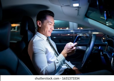 Asian Businessman Use Smartphone In The Car