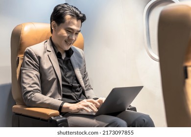 Asian Businessman Using Computer During Business Trip On Plane, Happy Asian Man Working With Computer Laptop On Flight, Smiling Chinese Handsome Man Working On Charter Flight, 