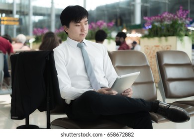 Asian businessman using digital tablet while waiting in lounge at airport.Business travel concept. - Shutterstock ID 658672882