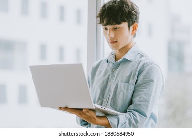 Asian Businessman Is Using Laptop To Work By Window
