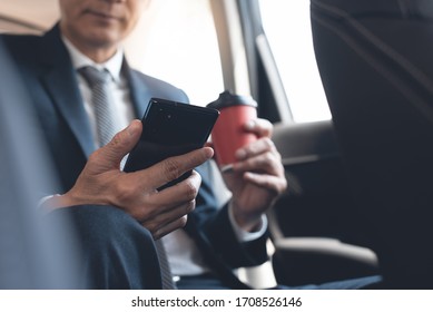 Asian Businessman Using Mobile Smart Phone Looking At Mobile Phone, Facetime Video Calling, Using Zoom Meeting Online App, Business And Technology Concept. Corporate Man Going To Workplace, Close Up