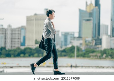 Asian businessman walking to work diligently and briskly in the morning in a big city. A man in a business suit, dressed in a smart suit, runs to work during rush hour in corridors and stairs. - Powered by Shutterstock