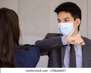 Asian Businessman Wear Face Mask Elbow Bump Greeting Instead Of Handshake. Concept Of New Normal Office Business During Coronavirus Pandemic Outbreak.