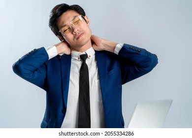 Asian Businessman Wear Formal Suit Sitting In Office Feeling Body Pain By Office Syndrome Various Symptoms Including The Inflammation Of Neck, Shoulder And Back Muscles Studio Shot White Background