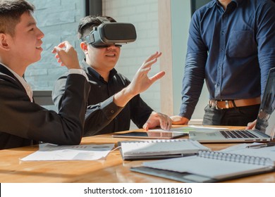 Asian Businessman Wearing Virtual Reality. VR Technology In The Future At A Meeting In Daylight On The Desk.