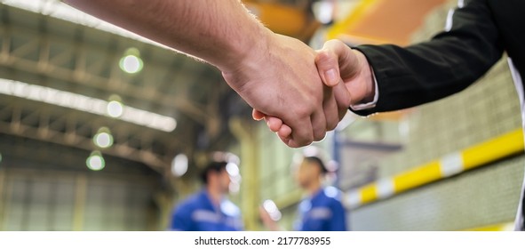 Asian Businessman And Woman Handshake After Negotiation In Manufactory. Attractive Industry Factory Engineer People Talking About Business Deal, Merger And Acquisition At Manufacturing Plant Warehouse