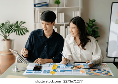 Asian businessman and woman people meeting in green office. Employee brainstorm and work as team, plan and discuss project by point on paper and tablet.  - Shutterstock ID 2273671277