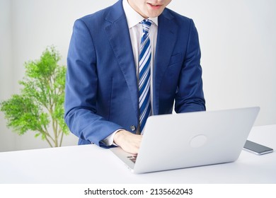 Asian Businessman Working With A Laptop At The Office, No Face