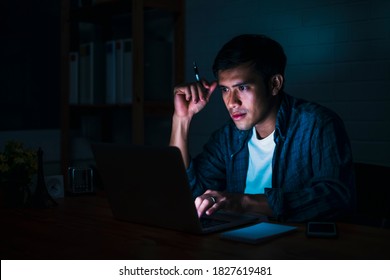 Asian Businessman Working Late Night In Front Using Computer Laptop Smart Mobile Phone Technology, Overtime Busy Schedule Focusing Hard Work At Home Modern Office Space Feeling Tired, Sleepy Stressful