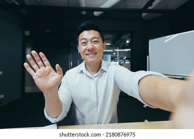 Asian Businessman Working In Modern Office, Successful Man Talking On Video Phone Call, Waving To Interlocutor And Smiling