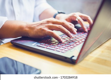 Asian businessman working on computer notebook in a coffee shop - Shutterstock ID 1703284918