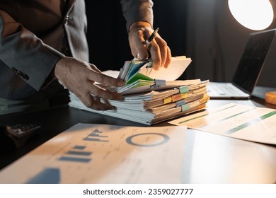 Asian businessman working on paperwork on desk Gather documents from meeting minutes. Documents financial Reports Accountant working in the office. Accounting concept. Business finance. - Shutterstock ID 2359027777