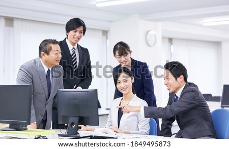 Asian businessmen and businesswomen talking at the office