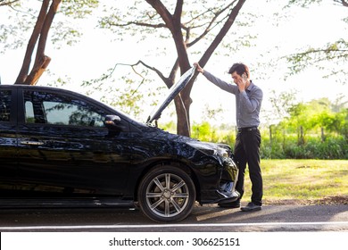 Asian Businessmen Talking On A Cell Phone By A Broken Car On Country Road Phoning For Help, Man Broken Car.Broken Car On The Road In During Rush Hour .