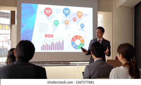 Asian Businesspeople Having On Presentation At Meeting Room