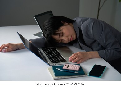 Asian businesswoman being tired after working overtime - Shutterstock ID 2254537467