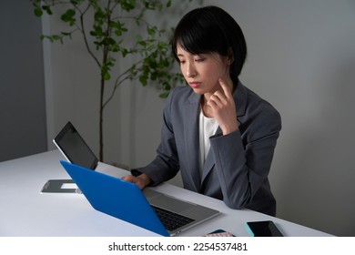 Asian businesswoman being tired after working overtime - Shutterstock ID 2254537481