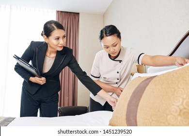 Asian Businesswoman In Black Suit Working As A Hotel Manager And She Controlling The Work Of Staff In The Hotel Room Before Guest's Arrival
