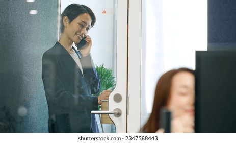 Asian businesswoman calling in individual work booth. - Powered by Shutterstock