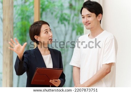 asian businesswoman explaining interior of house for young man