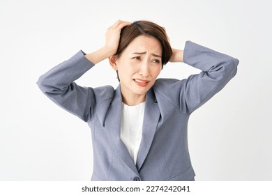 Asian businesswoman holding her head in white background - Shutterstock ID 2274242041
