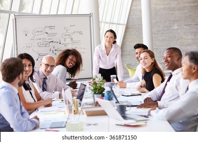 Asian Businesswoman Leading Meeting At Boardroom Table