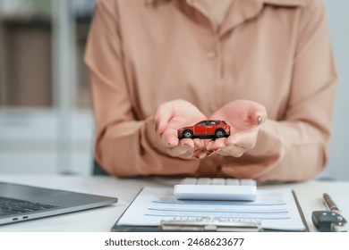 Asian businesswoman negotiates the sale of a car, discussing insurance and financing options, used car loans, premiums, deductibles, and various coverage types to ensure comprehensive protection. - Powered by Shutterstock