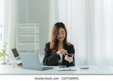 Asian Businesswoman Relax And Enjoy Chatting Mobile Phone At Office.