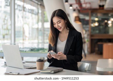 Asian Businesswoman Relax And Enjoy Playing Mobile Phone At Office.