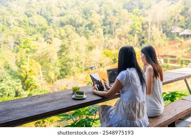 Asian businesswoman remote working online corporate business on laptop computer and digital tablet with internet at cafe. Woman freelancer enjoy outdoor lifestyle work and travel on holiday vacation. - Powered by Shutterstock