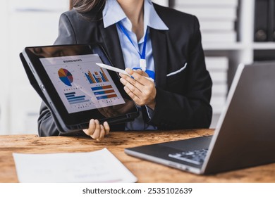 Asian businesswoman showing financial charts during video call. - Powered by Shutterstock