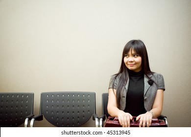 asian businesswoman sitting alone in the waiting room for an appointment