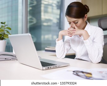 Asian Businesswoman Sitting In Office, Looking Tired.